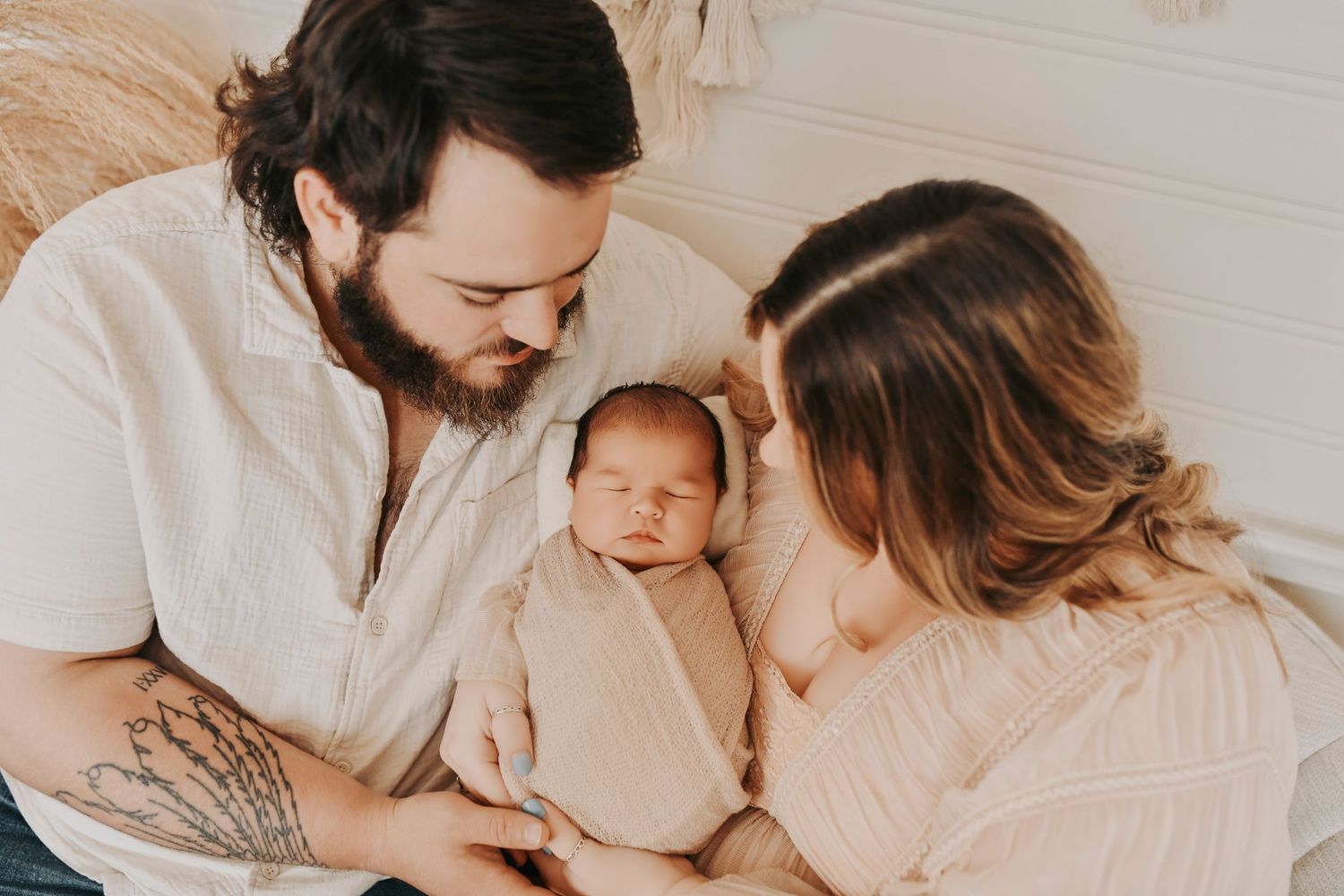 Parents gently rocking their newborn in a calm newborn session