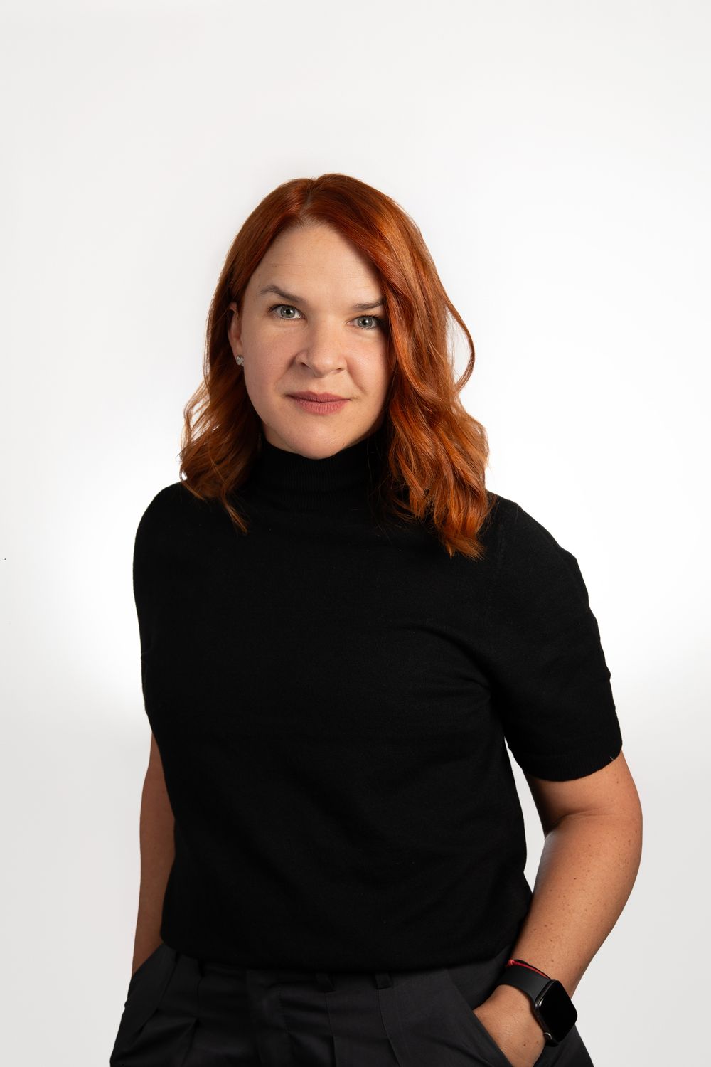 Professional headshot of a red headed woman in a black sweater in NYC