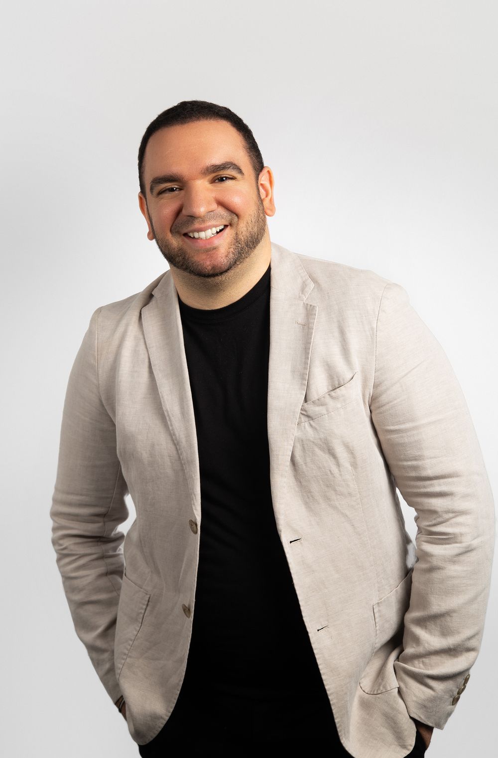 Professional headshot of a man in a tan jacket in NYC