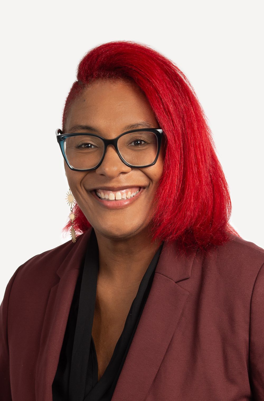 Professional headshot of a woman in a burgundy jacket in NYC