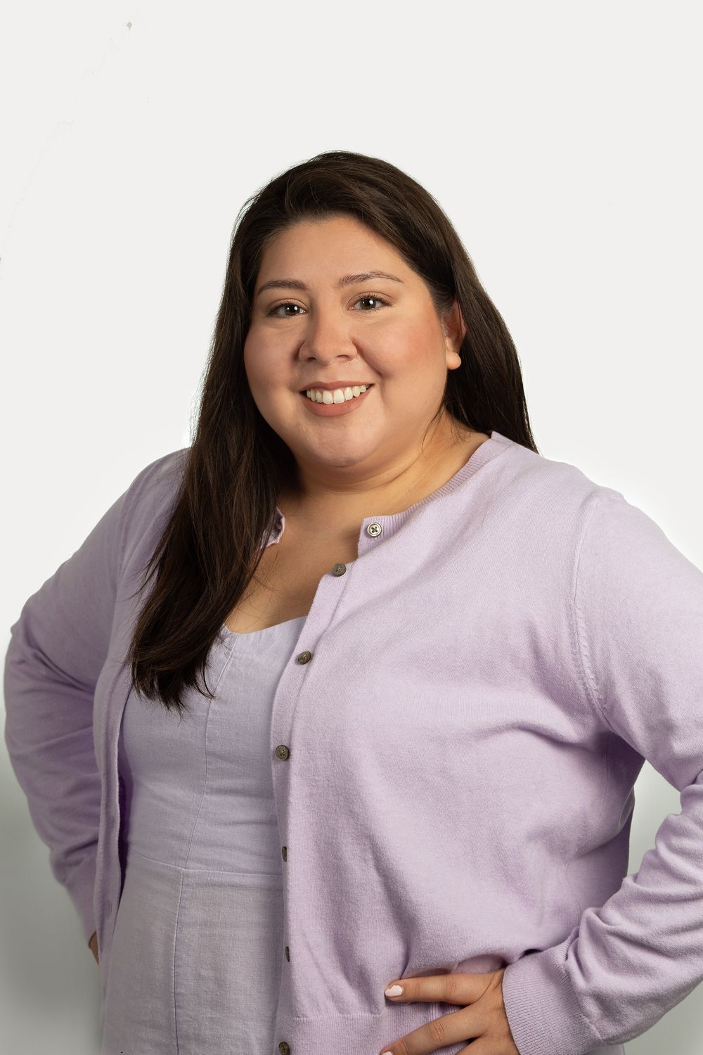 Professional headshot of a young woman in a lavender sweater in NYC