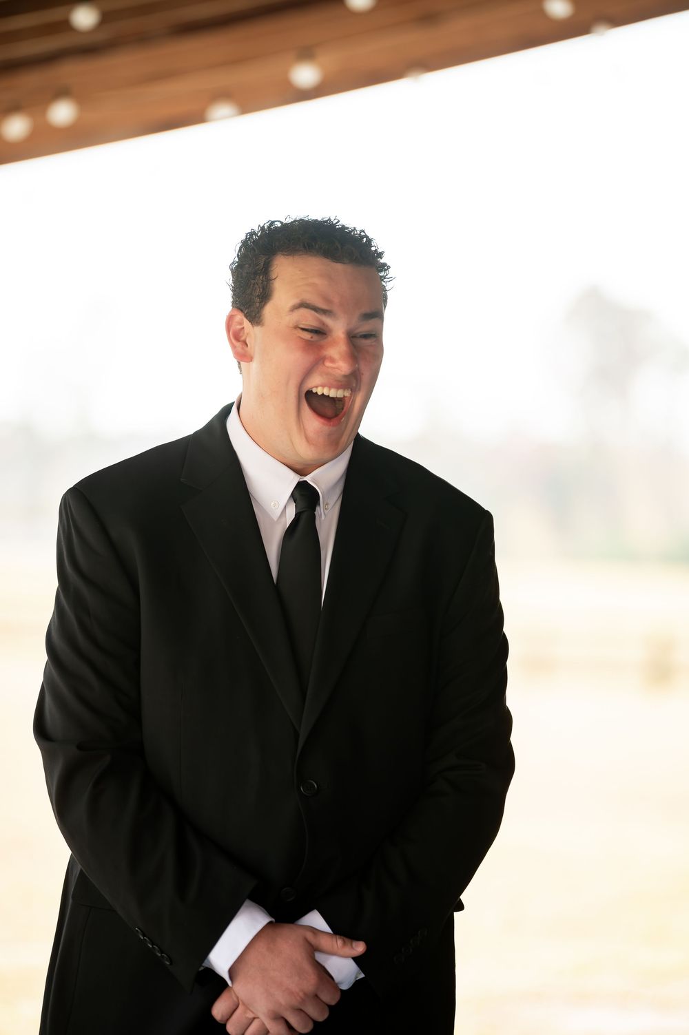 Joyful reaction during wedding first look in rustic barn setting.