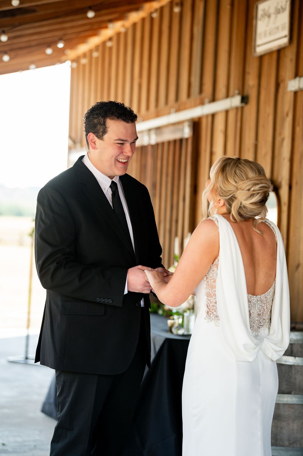 Candid wedding moment captured between couple in rustic wooden venue.