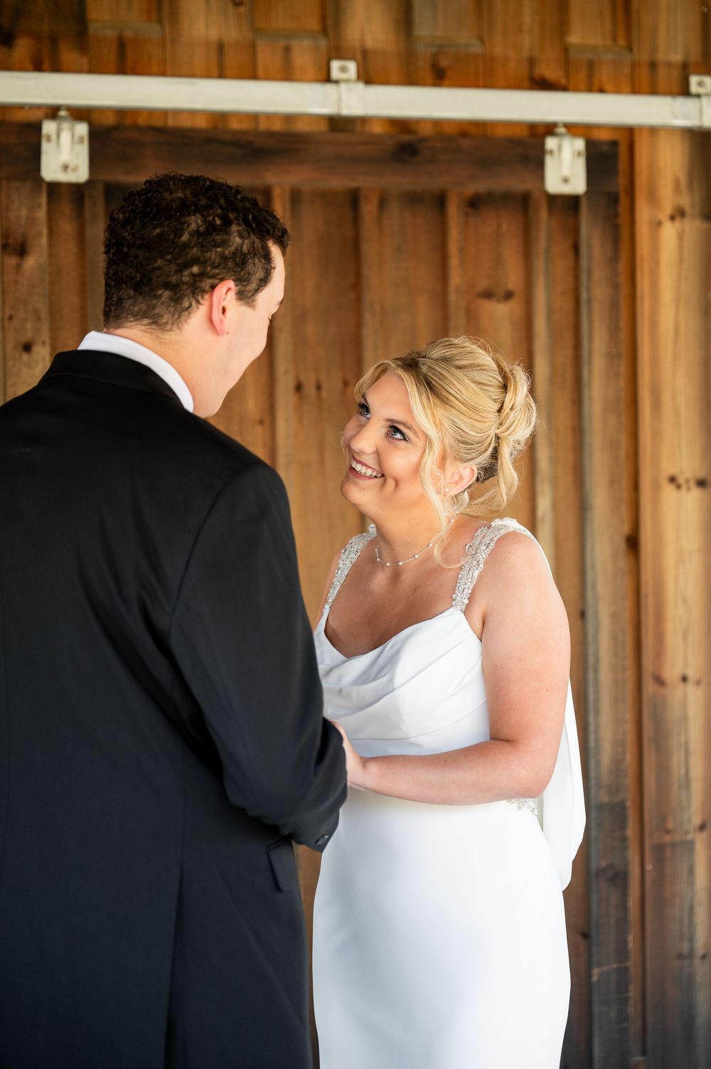 A joyful wedding moment captured inside a rustic wooden barn setting.
