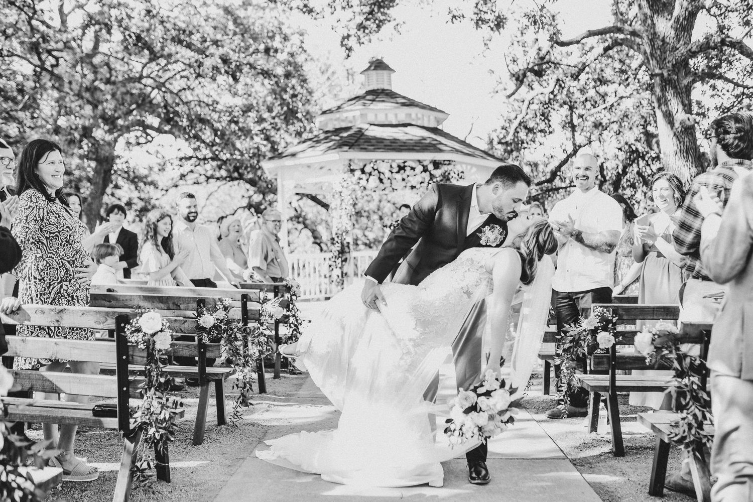 Romantic moment between bride and groom during their spring wedding ceremony at Towering Oaks, framed by natural greenery.