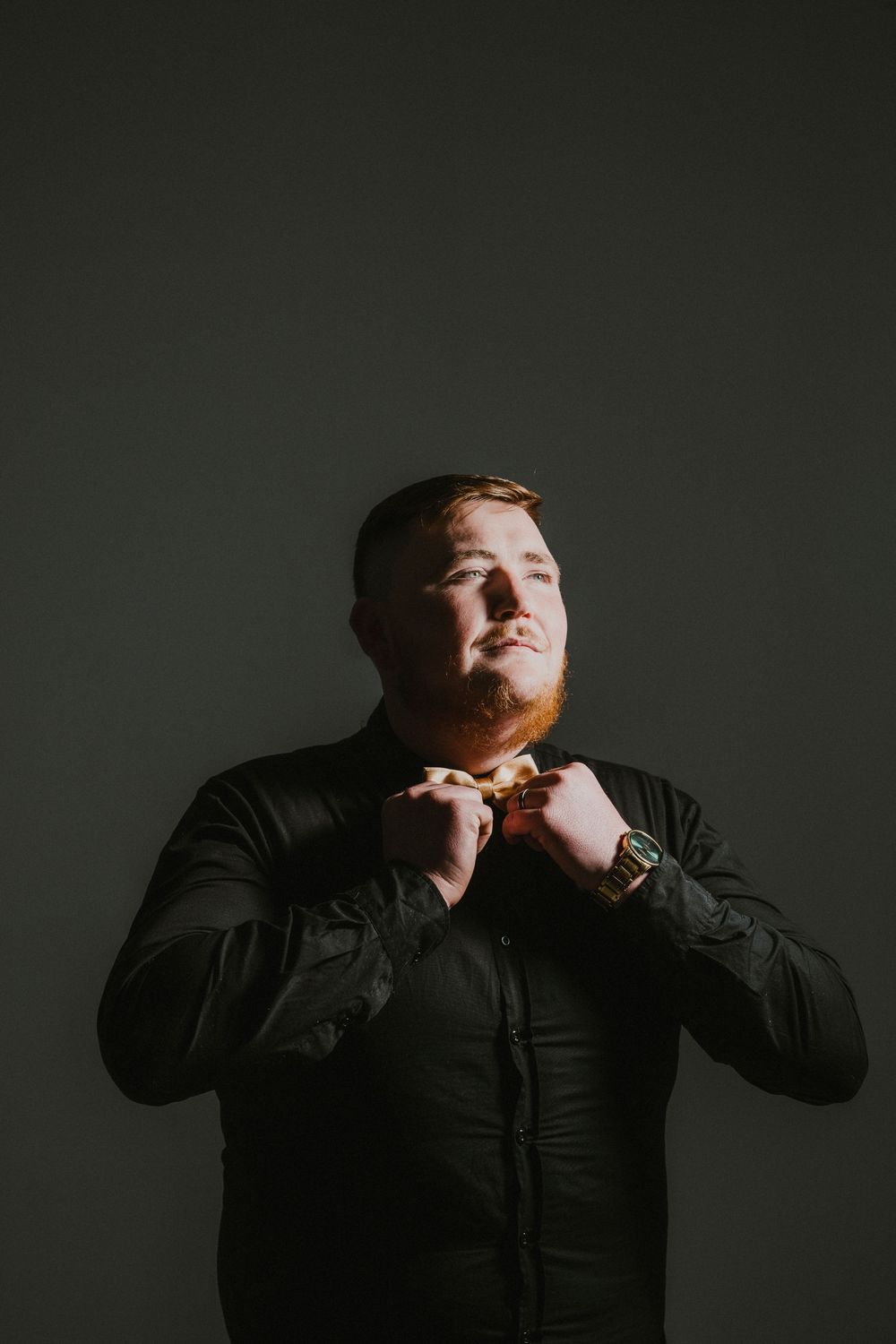 A series of four dramatic portraits showing someone in a black shirt against a dark background eating or biting something.