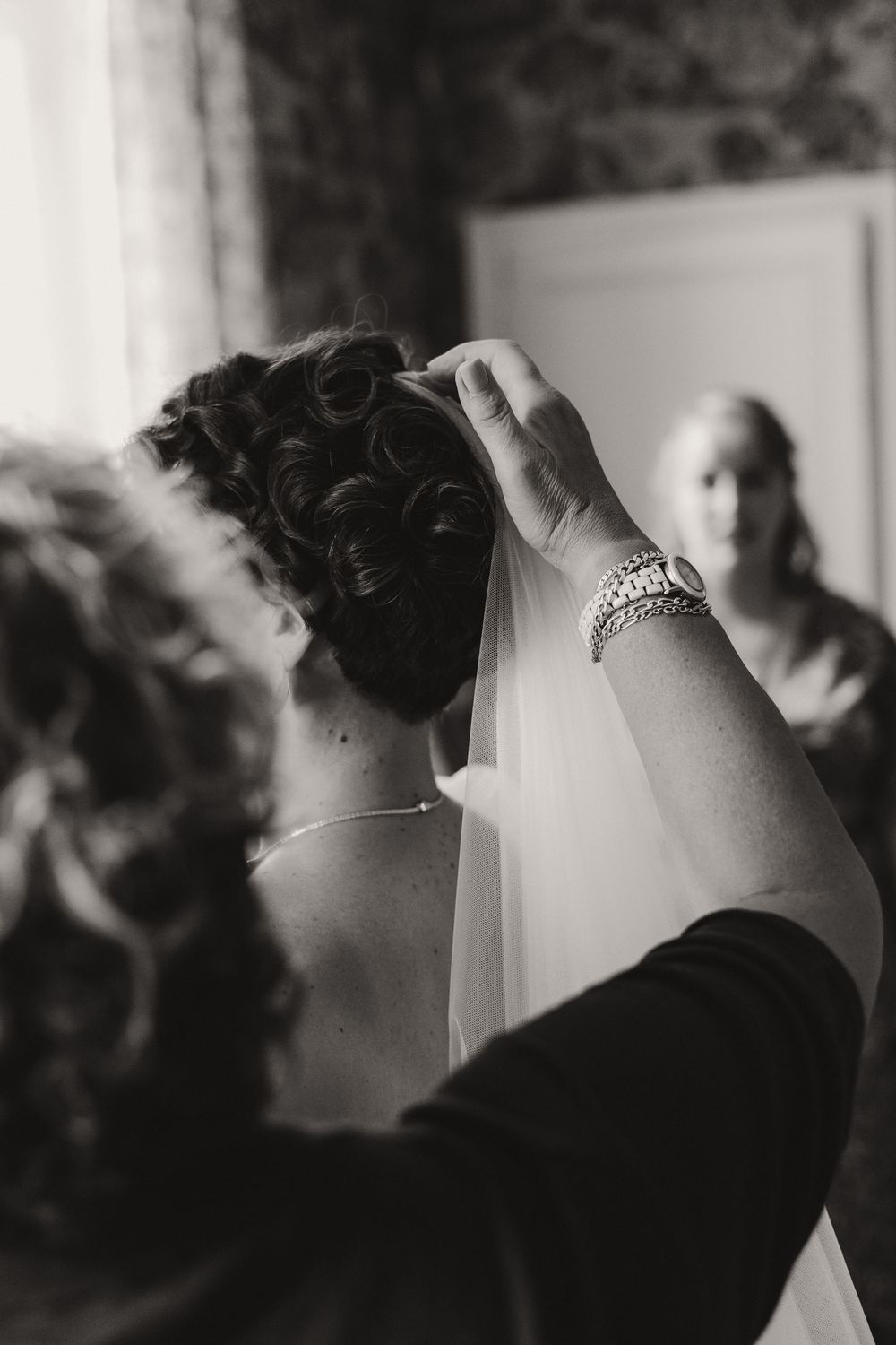 Silhouette of person with curled hair and veil getting ready for wedding ceremony.