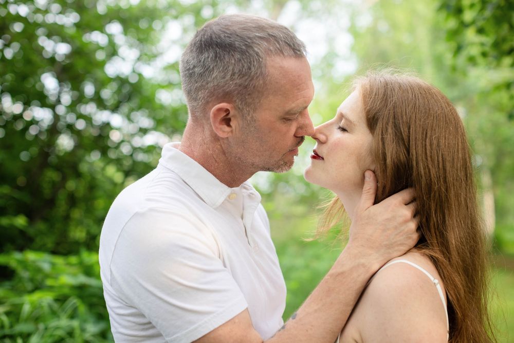 Romantic couple shares tender moments in a series of outdoor photos against lush green foliage.