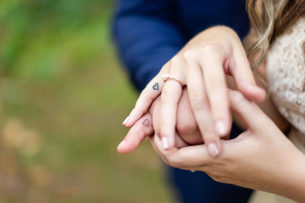 Close-up shots showing hands exchanging wedding rings during an outdoor ceremony.