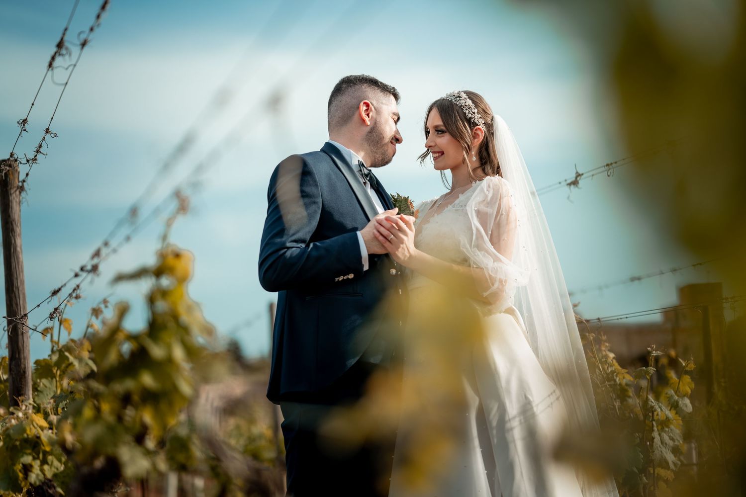 Romantic moment captured in a sunlit vineyard setting.