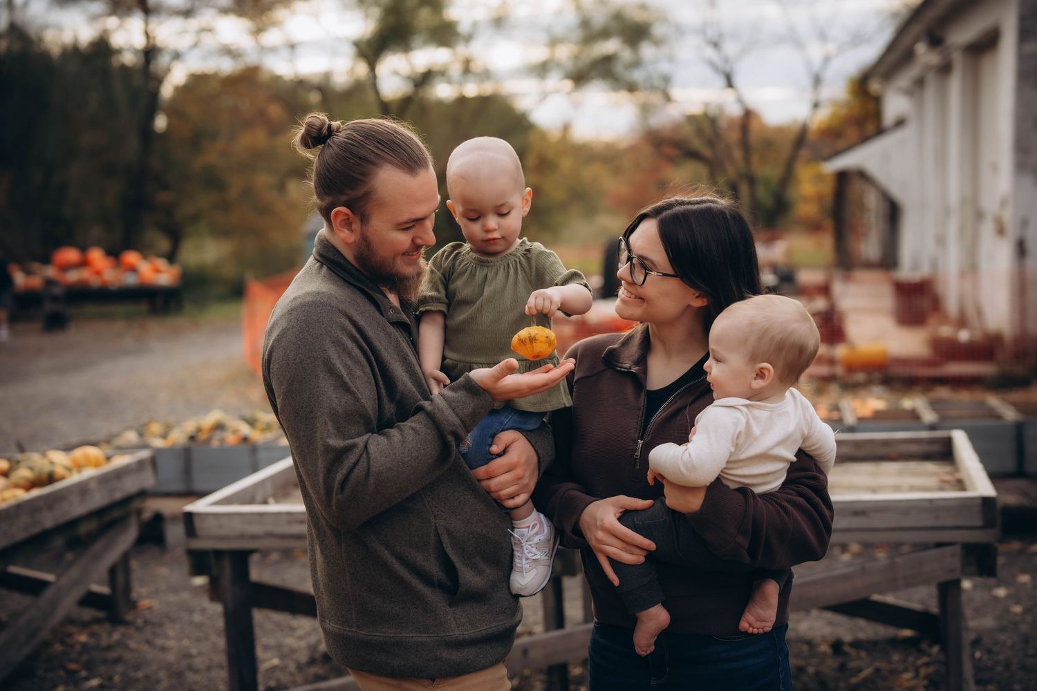A family shares tender moments together outdoors during a sunset photo session.