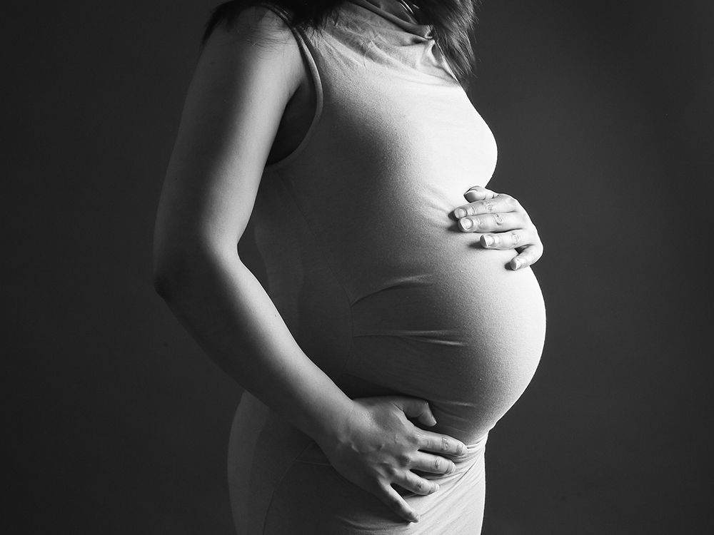 Pregnant woman in studio wearing elegant dress, maternity session High Wycombe
