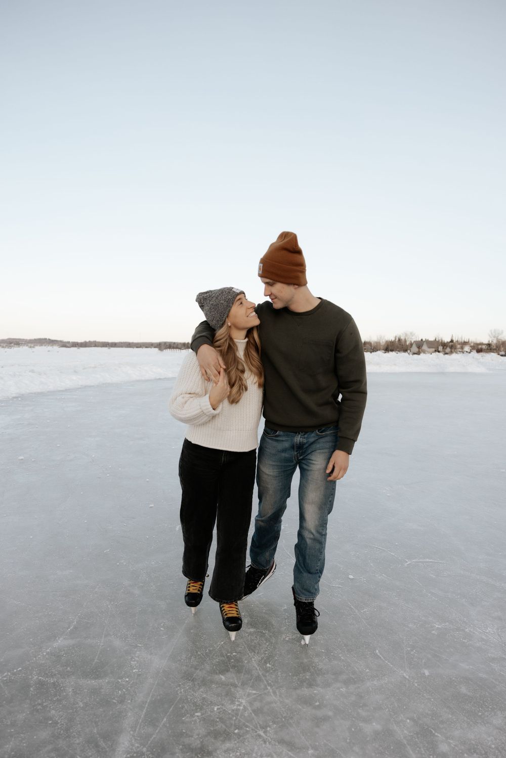 Couple walking together on a frozen lake in winter, shown in a series of candid shots from behind.