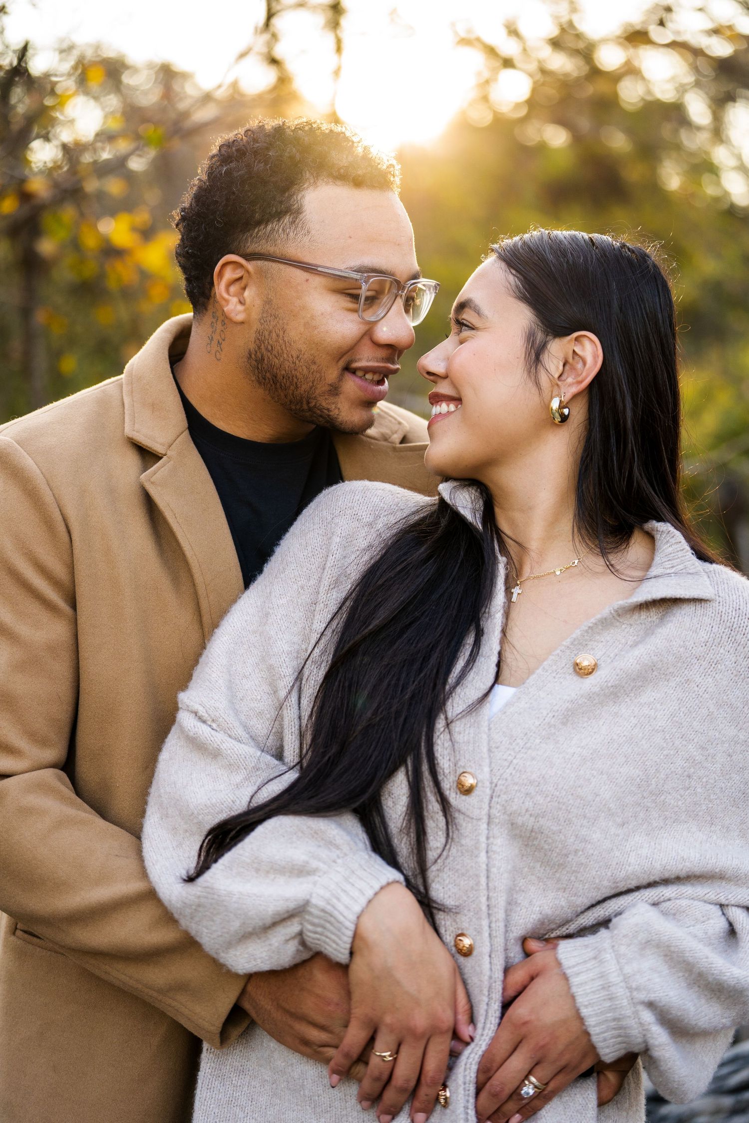 Romantic outdoor couple portrait during golden hour with warm autumn lighting.