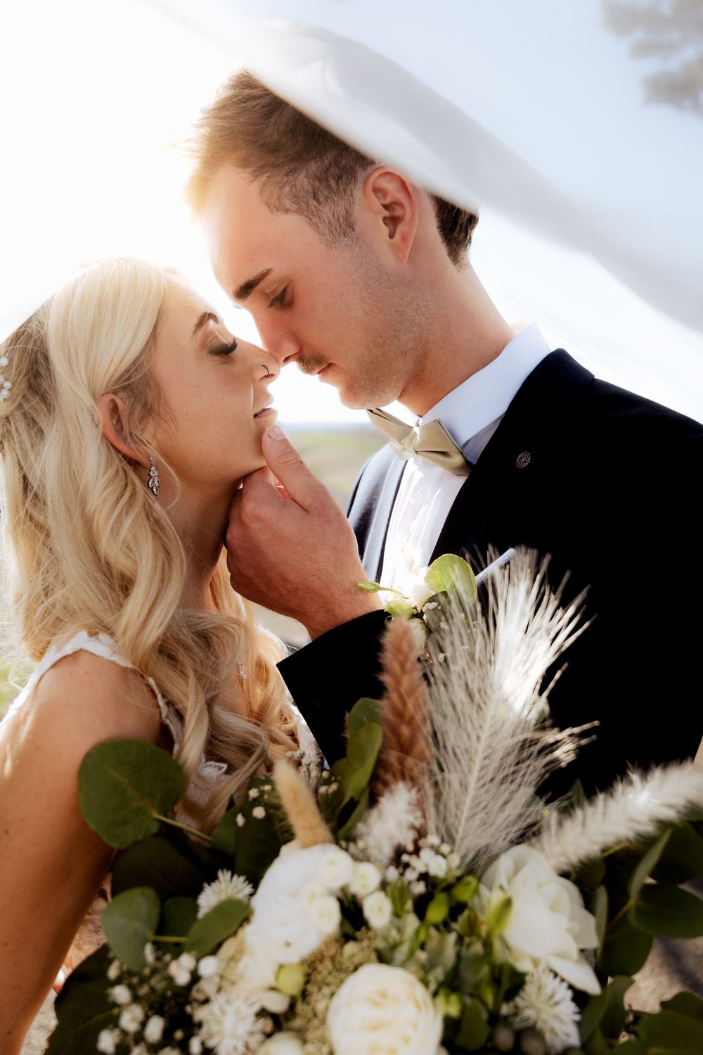 Romantic wedding couple shares intimate moments in three similar poses with pampas grass and floral bouquet details.