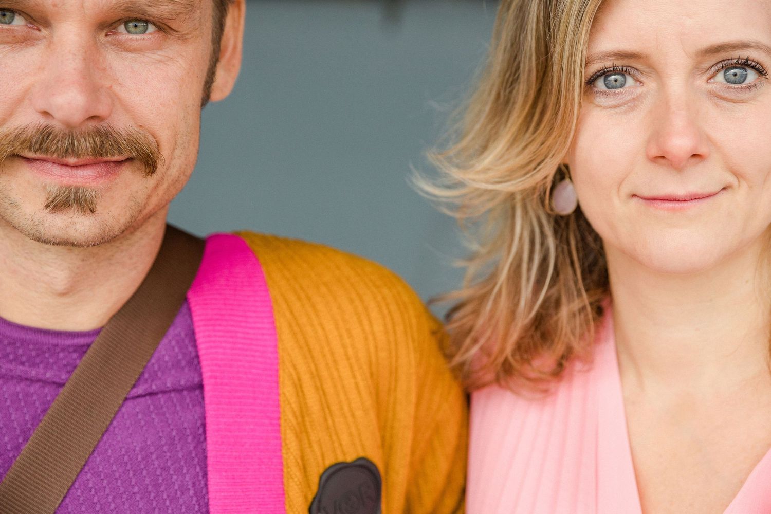 A contrasting couple purple and orange sweaters posing together. Wedding planners from MyCastleWedding from Dresden