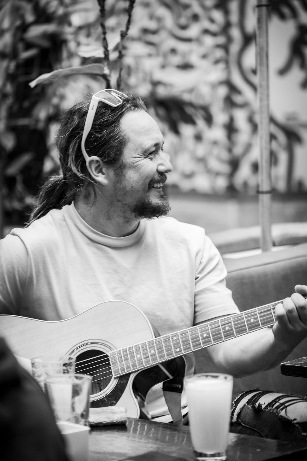 A man plays guitar at a cafe table