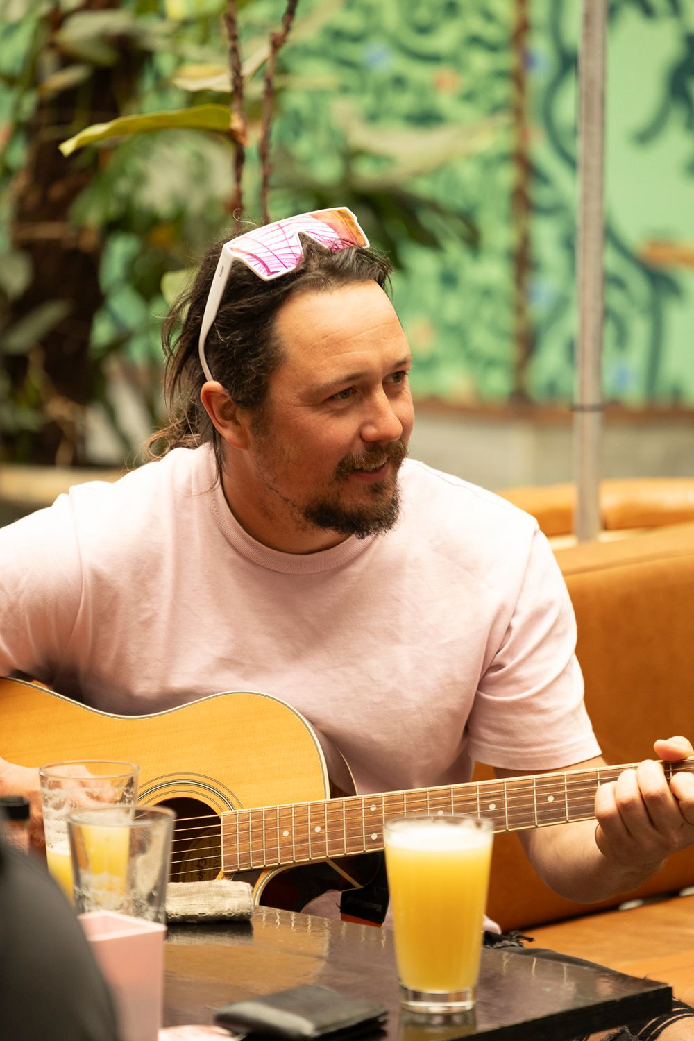 A man plays guitar at a cafe table