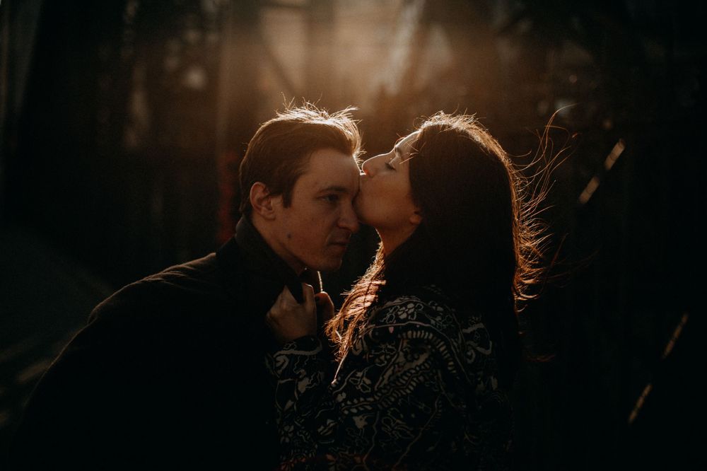 Romantic backlit silhouette of couple in warm sunset lighting.
