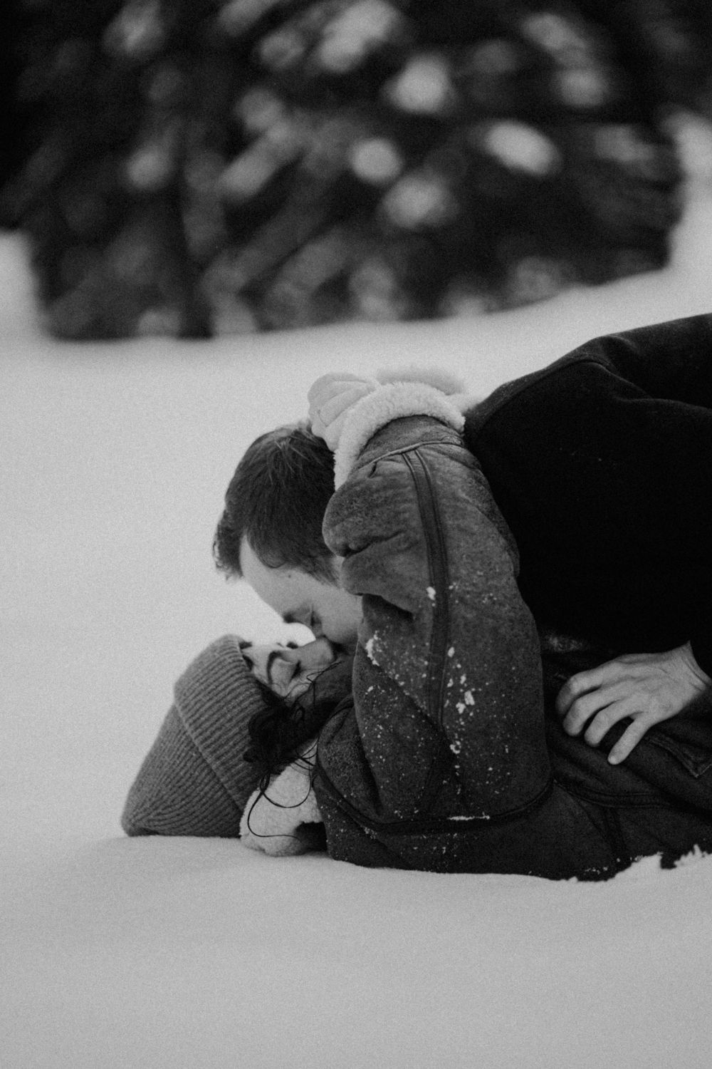 Black and white photo of intimate moment in snow covered landscape.