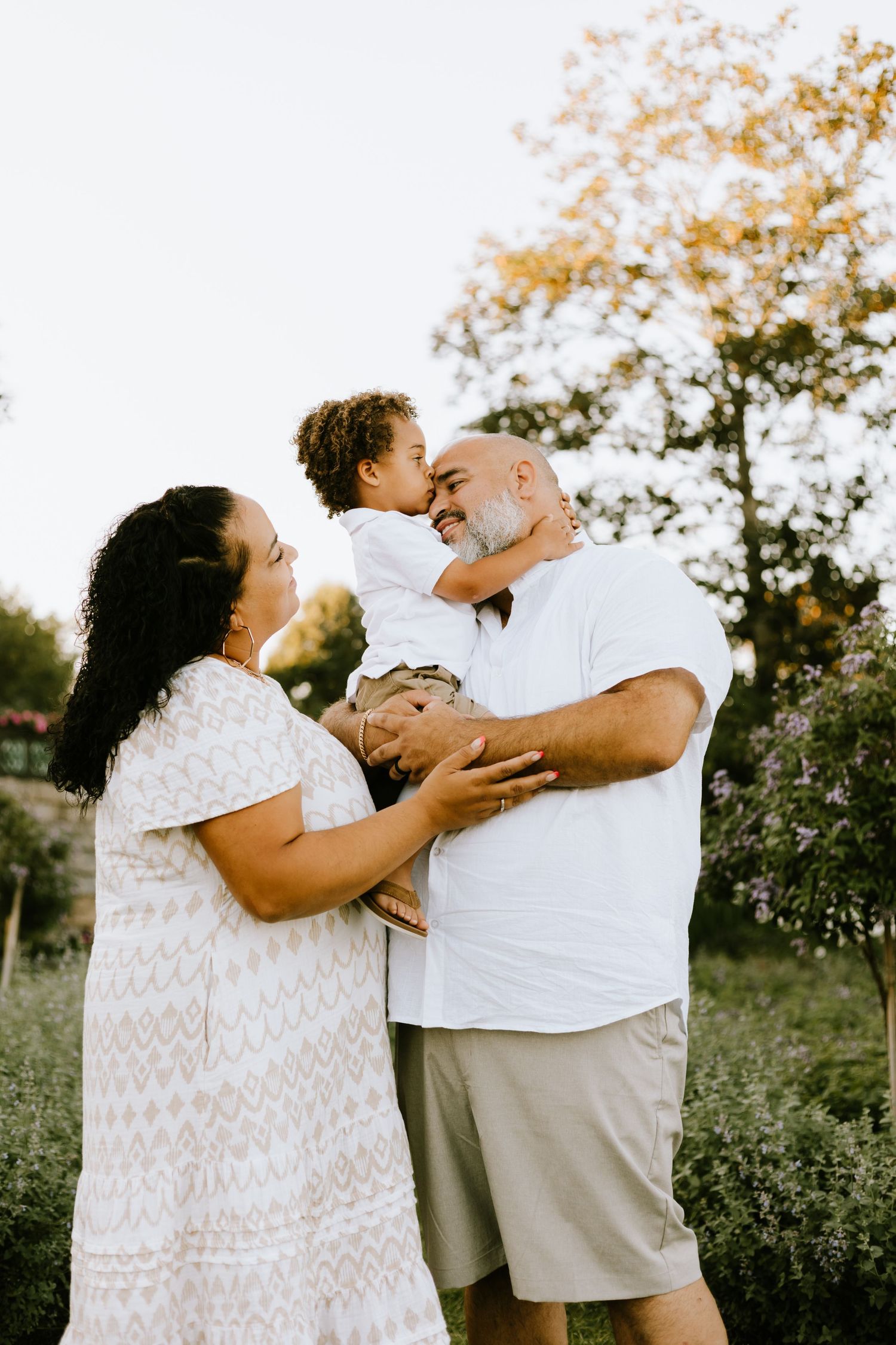 Family sharing playful moment together in garden during sunset.