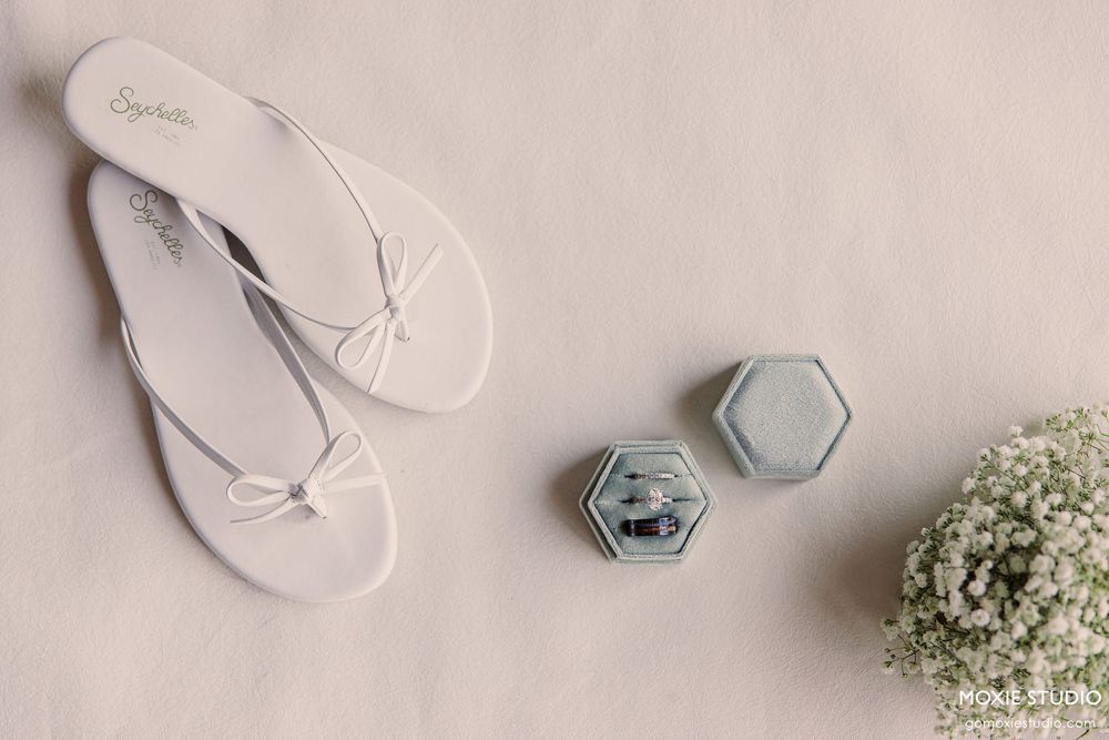 White wedding flip flops and decorative elements arranged on a light background.