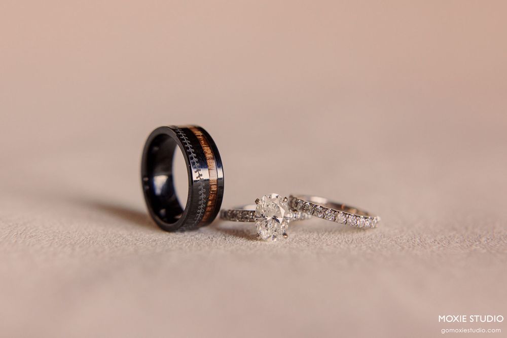 Wedding rings arranged in a minimalist composition on a beige textured surface.
