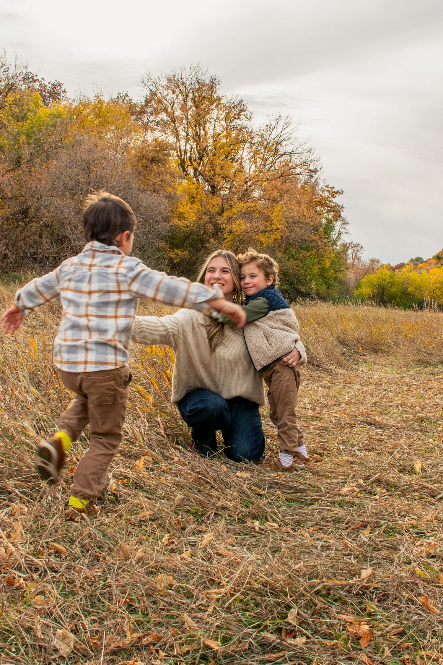 A small family in Layton Utah acting happy and candid in a warm hug.