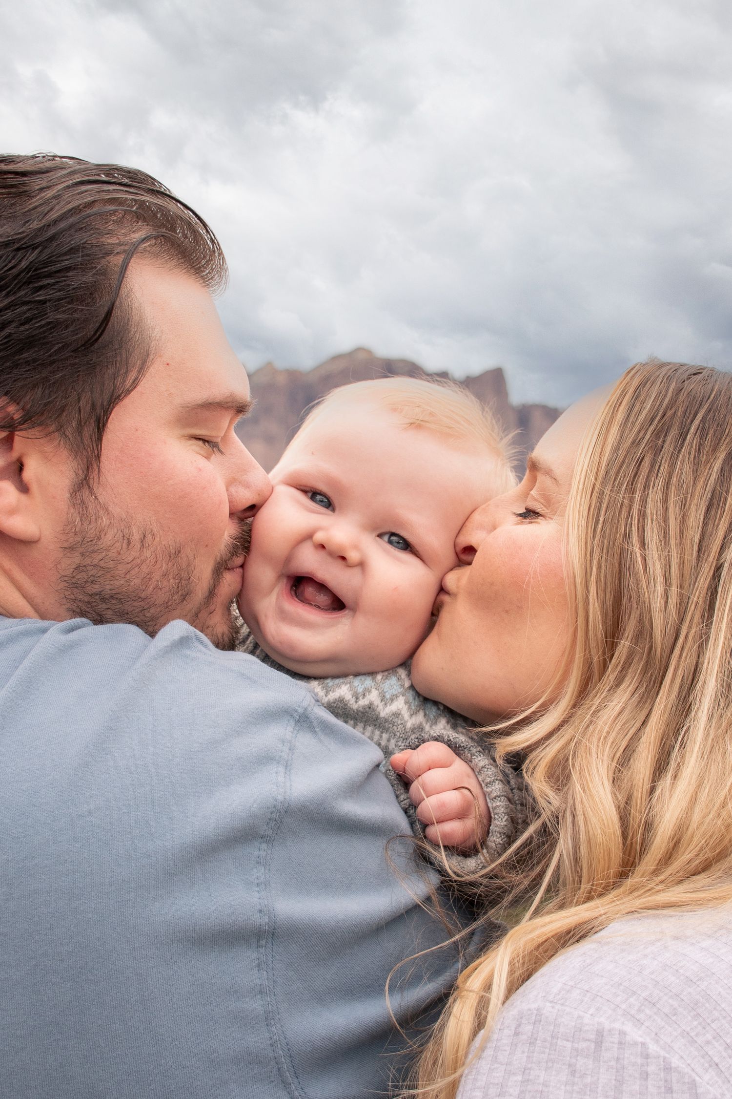 A sweet family moment captured in a series of photos showing parents kissing their baby in Mesa, Arizona.