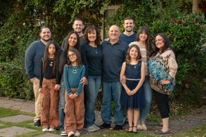 Extended family group portrait outdoors with green foliage background in Mesa, Arizona.
