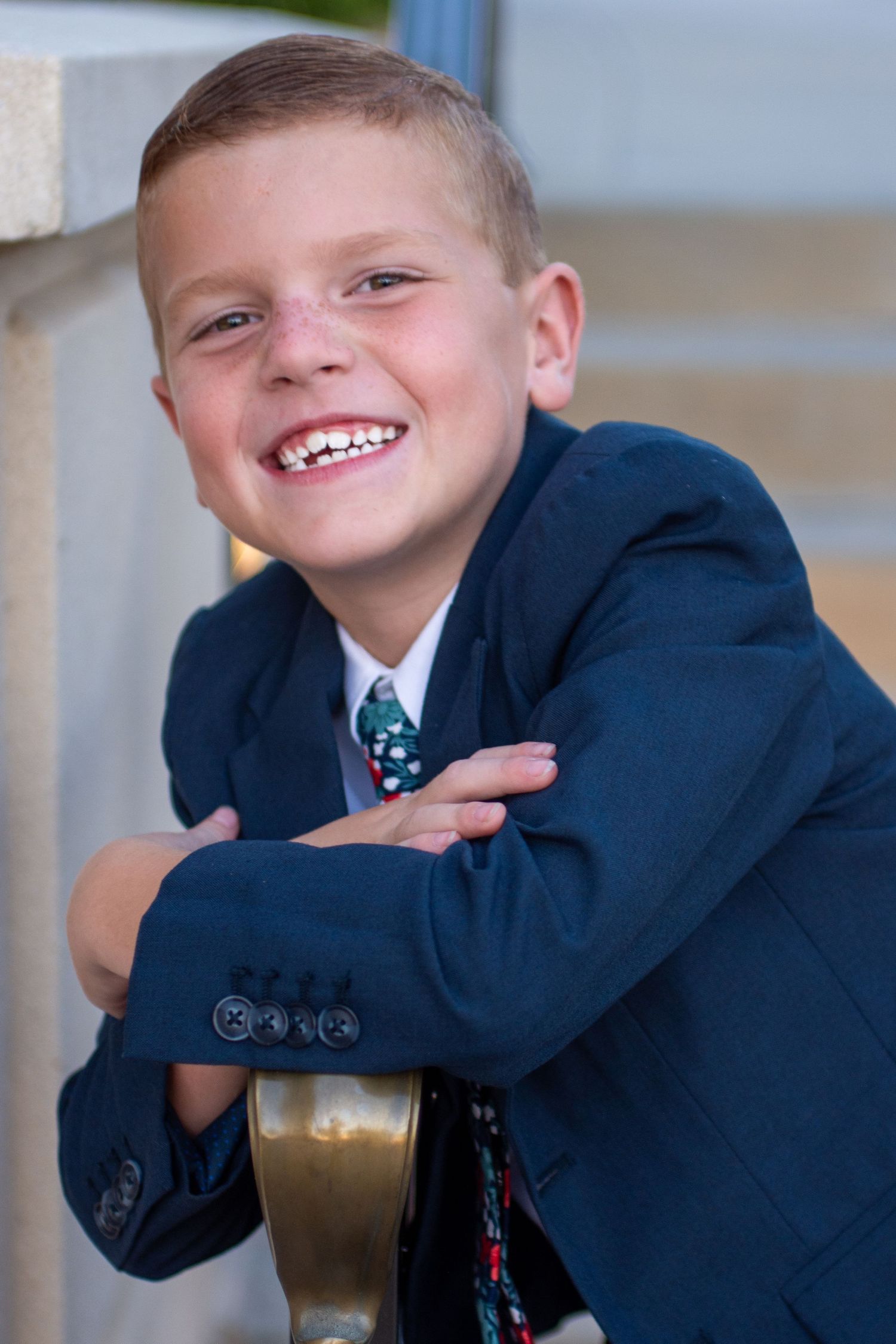 Cute 8-year-old boy grins in front of Utha temple for his baptism photos.