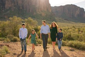 Family walking together against scenic desert mountain landscape in Mesa, Arizona.
