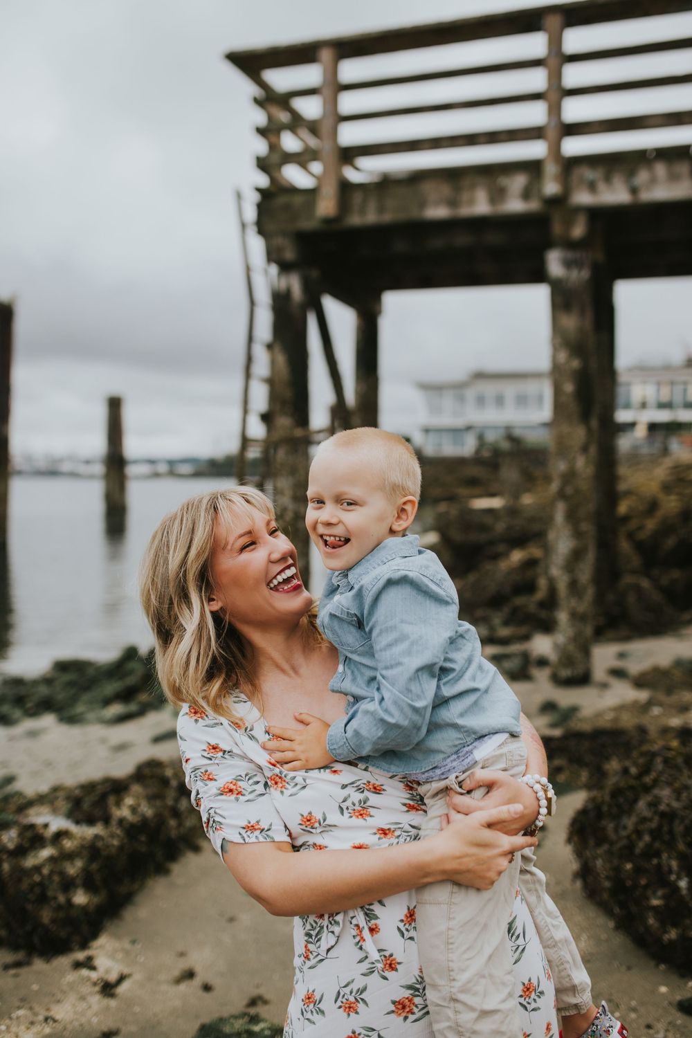 Mother and son laughing on gloomy Alki waterfront in the greater Seattle area.