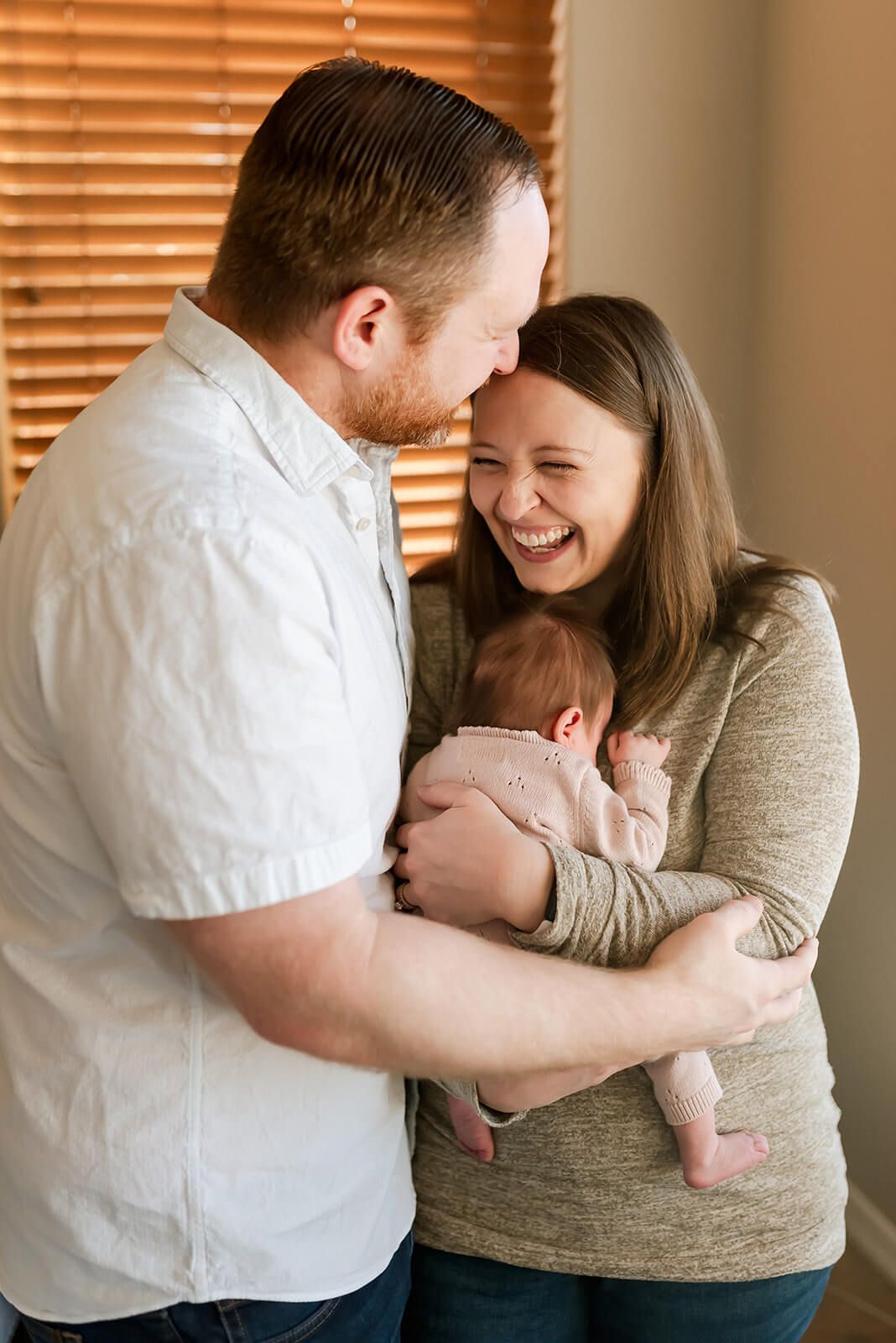 A tender family moment as parents embrace their newborn baby.