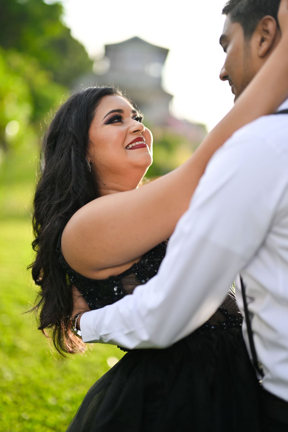 Joyful couple sharing an intimate dance moment in a garden setting.