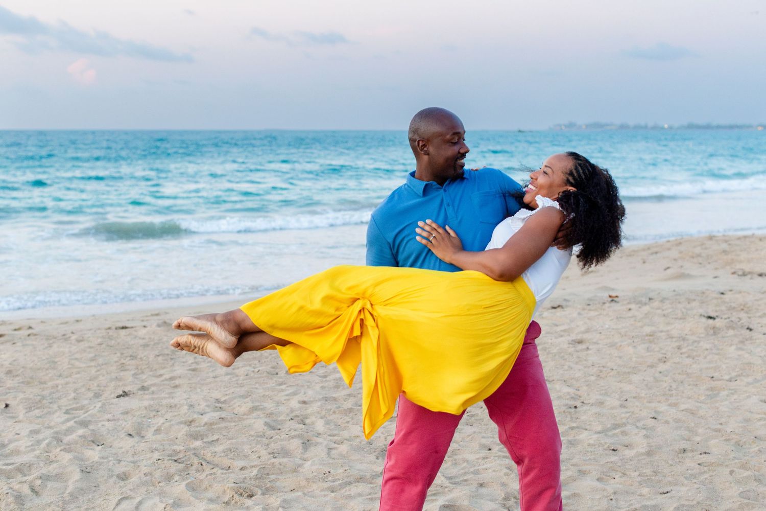Couples portrait. Man carrying wife on the beach in Isla Verde, Carolina, Puerto Rico.