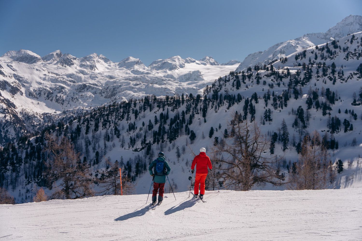 deux skieurs de dos à la rosière avec les montagnes italiennes en arrière-plan
