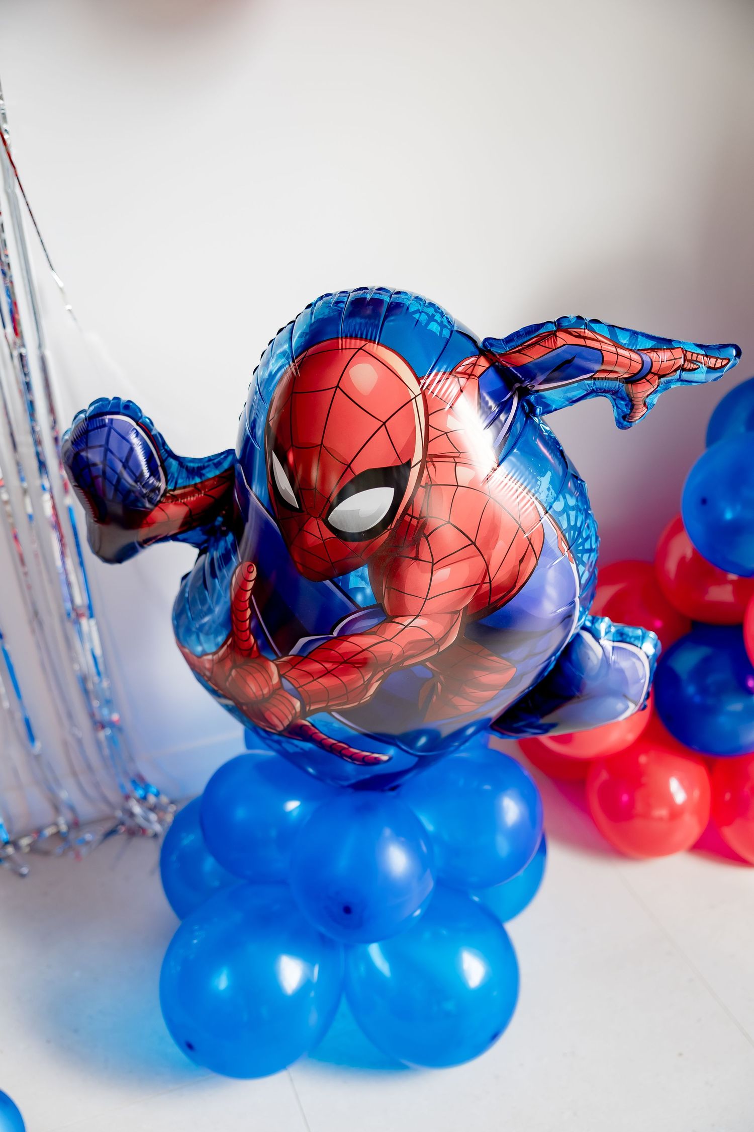 Spiderman foil balloon display with blue and red latex balloons at a superhero themed birthday party.