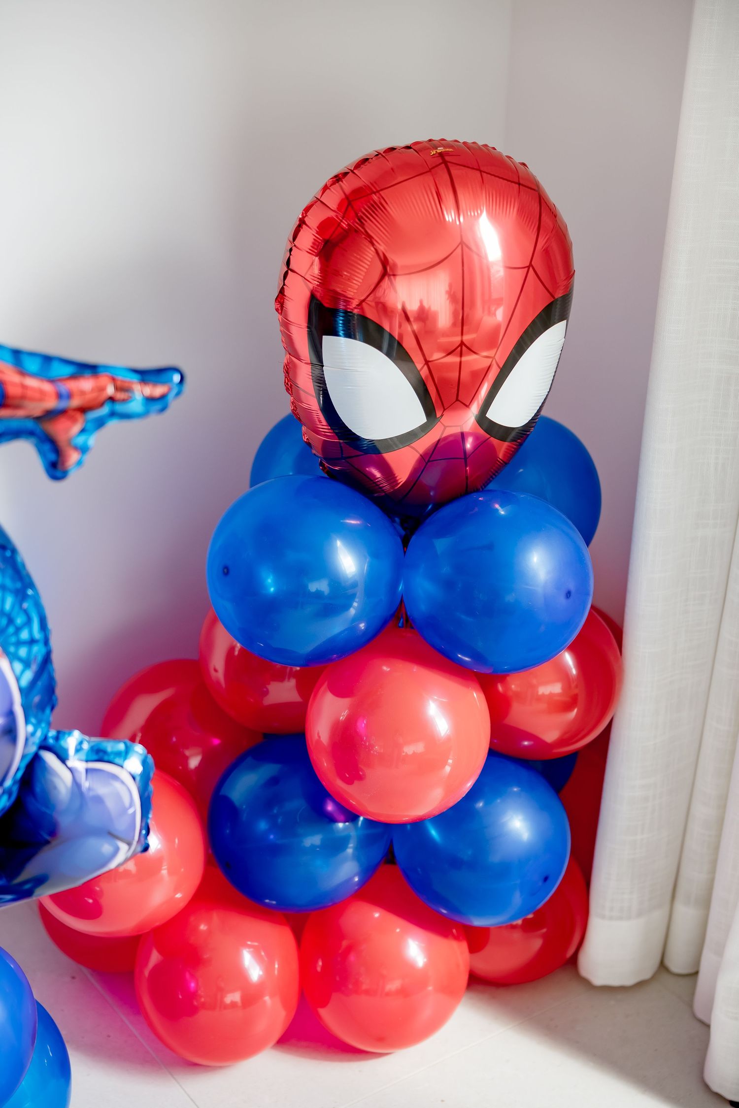 Spiderman balloon tower with red and blue balloons at a themed birthday party.