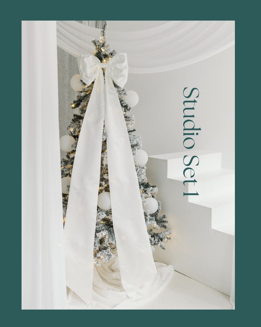White Christmas tree with large bow, ornaments, and draping fabric in a bright studio photography set.