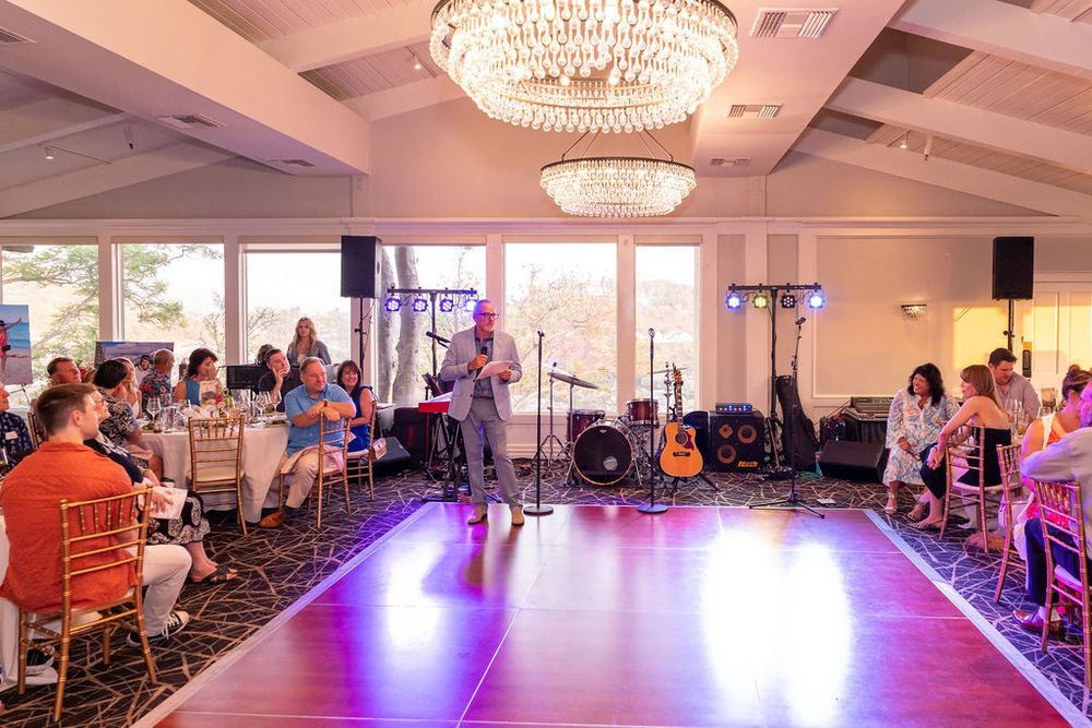 Elegant ballroom event with live band, dance floor, and chandelier lighting at a wedding reception.