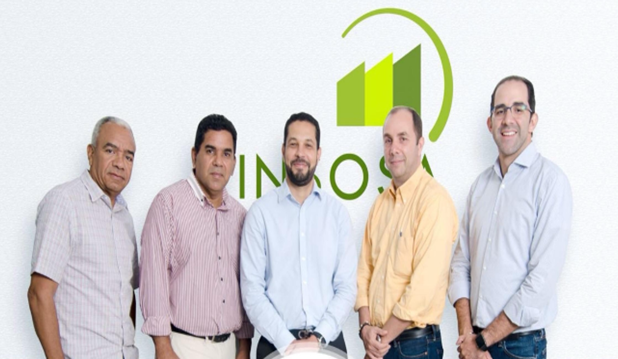 Five professional real estate team members posing in front of INKO company logo on white wall.