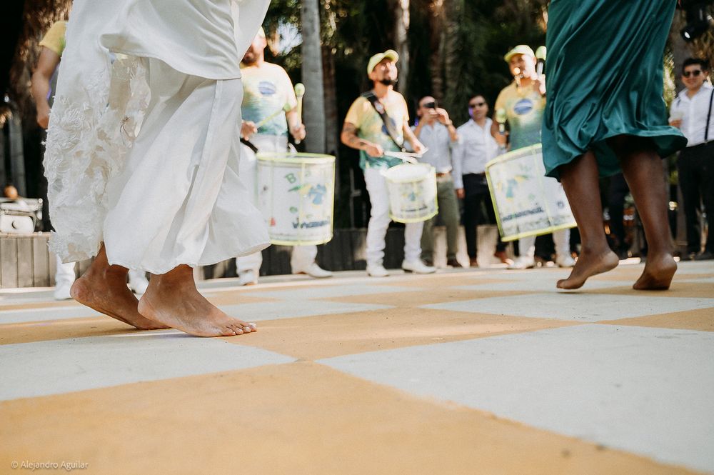 Barefoot dancers perform traditional Brazilian Candomble ritual outdoors with drummers holding instruments in background.