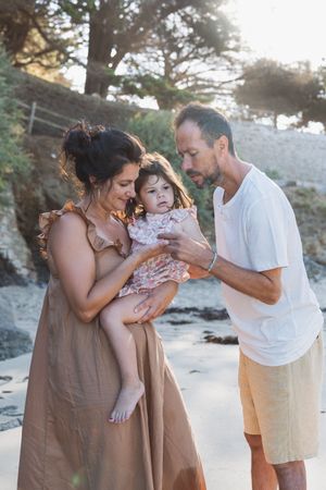 Moment de complicité entre les parents et leur enfant au bord de la mer