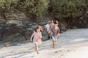 Enfants jouant dans le sable avec leurs parents lors d'une séance photo