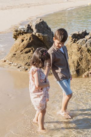 Enfants marchant dans la mer à Saint Lunaire