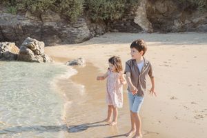Enfant jouant dans le sable pendant une séance photo famille