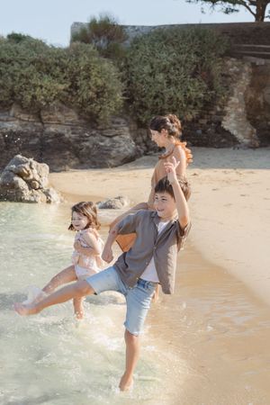 Enfants jouant dans les vagues avec leurs parents