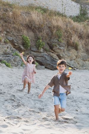 Enfants courant sur la plage pendant une séance photo famille naturelle
