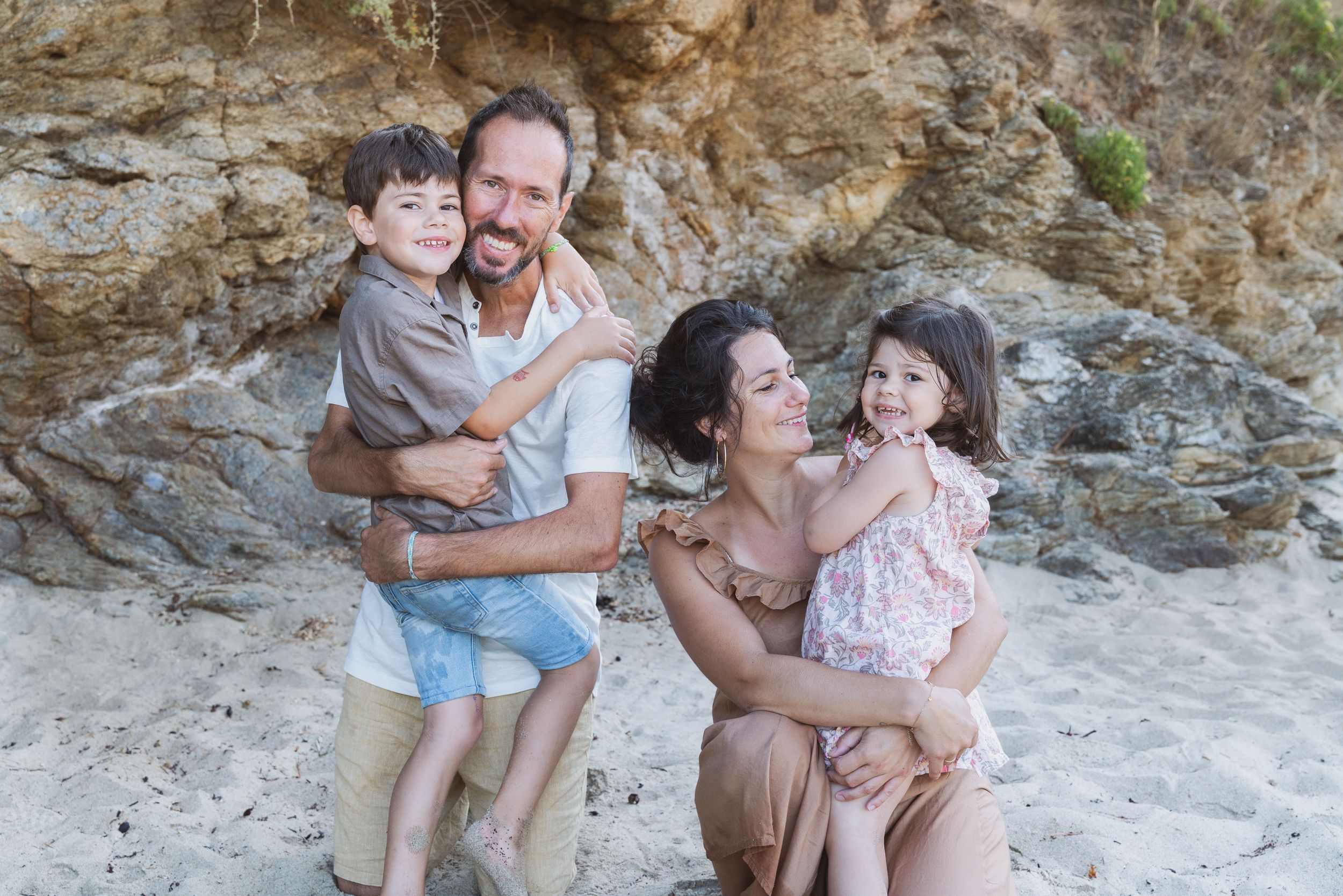 Parents faisant un câlin à leurs enfants sur la plage
